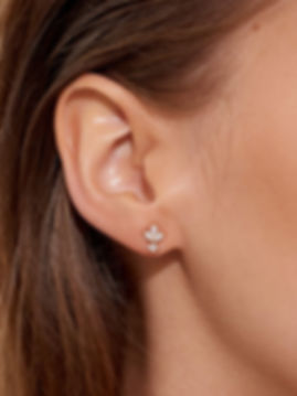 diamantové svatební náušnice ve tvaru květu na uchu modelky zlaté osazení