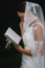 Nevěsta v elegantních svatebních šatech, drží otevřený svatební slib