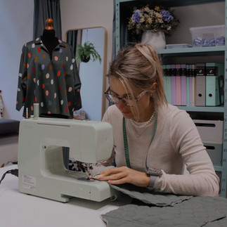 žena šije na šicím stroji
